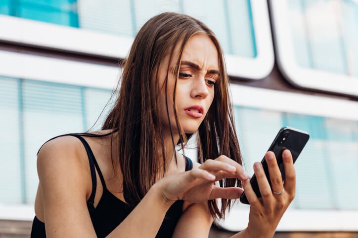 žena si pozerá príspevok na instagrame a tvári sa nespokojne