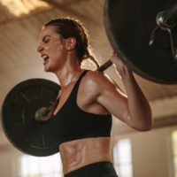 Strong woman exercising with heavy weights